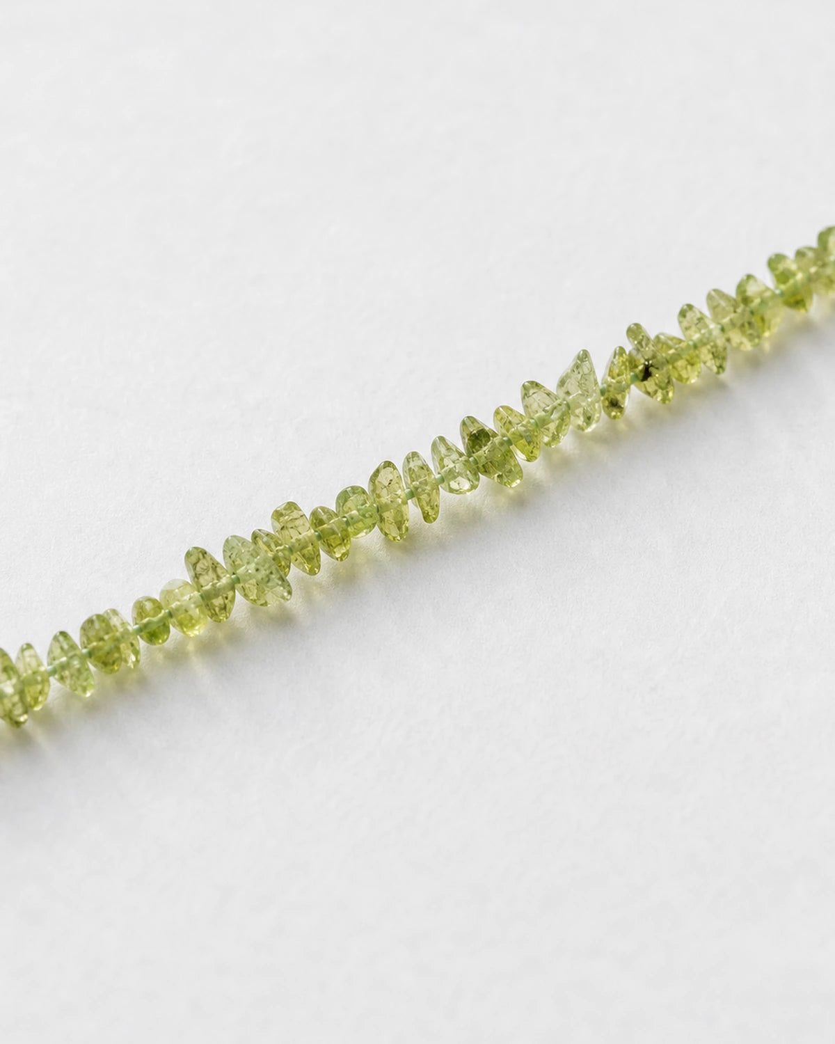 Close-up of polished peridot chip bracelet beads